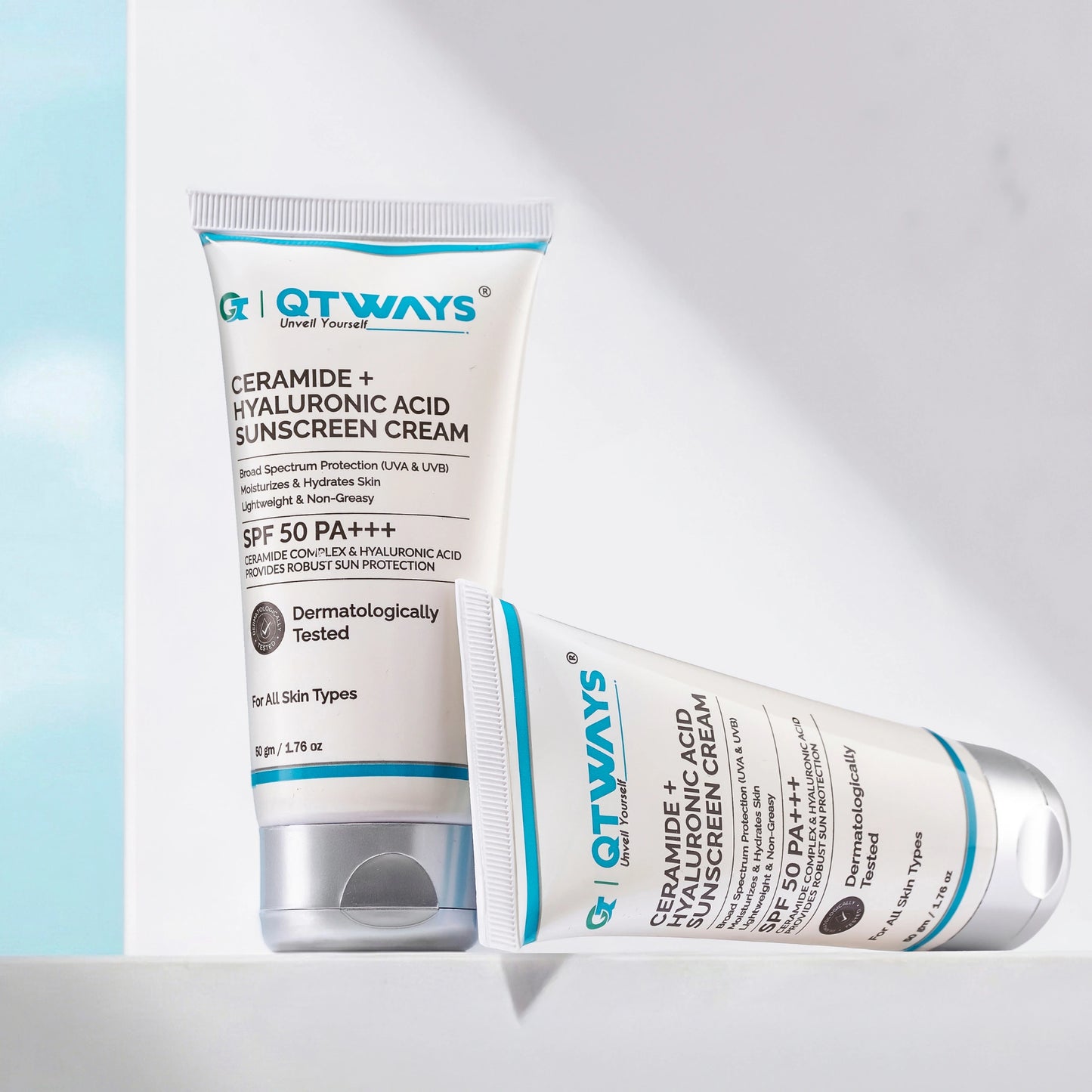 Two tubes of Qtways Ceramide and Hyaluronic Acid Sunscreen SPF 50 PA++++ displayed in a minimal setting, showcasing a lightweight, non-greasy daily sunscreen with broad spectrum UVA and UVB protection for all skin types.